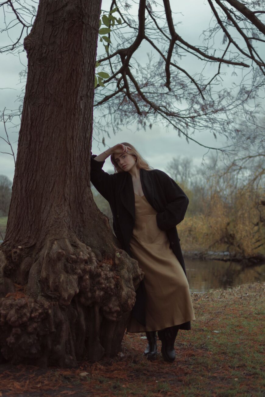 editorial portrait of model leaning by tree in Amsterdam