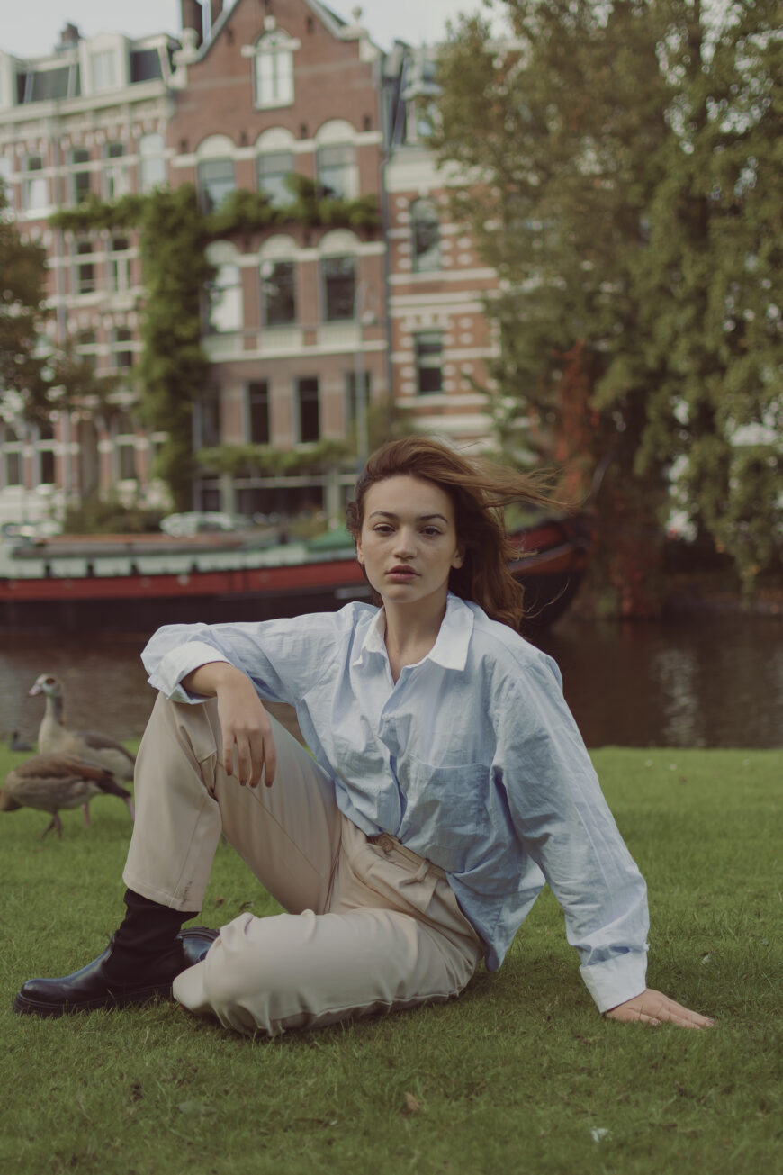 Editorial photoshoot with Amsterdam canal houses in the background in a park